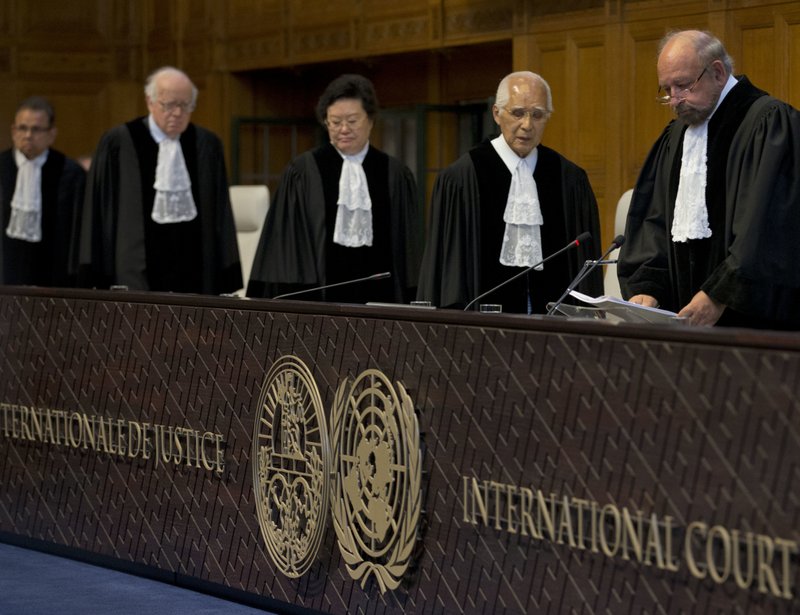 Presiding judge Ronny Abraham of France, right, enters to read the World Court's verdict in the case brought by India against Pakistan in The Hague, Netherlands, Thursday, May 18, 2017. India took Pakistan to the United Nations' highest court in an attempt to save the life of an Indian naval officer sentenced to death last month by a Pakistani military court after being convicted of espionage.