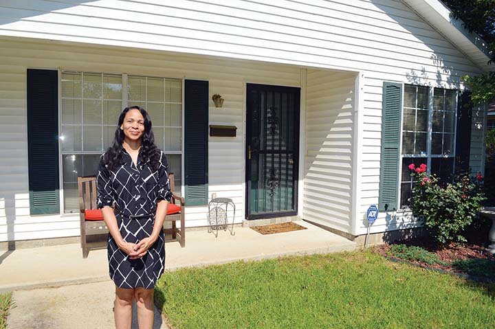 Tiesha Moore stands in front of her Habitat for Humanity of Faulkner County home in Conway, which she owns after paying off the mortgage three years early. “I thank Habitat for believing in me and giving me a chance,” Moore said. A respiratory therapist, Moore is getting married and said she plans to sell the home and find a larger one.