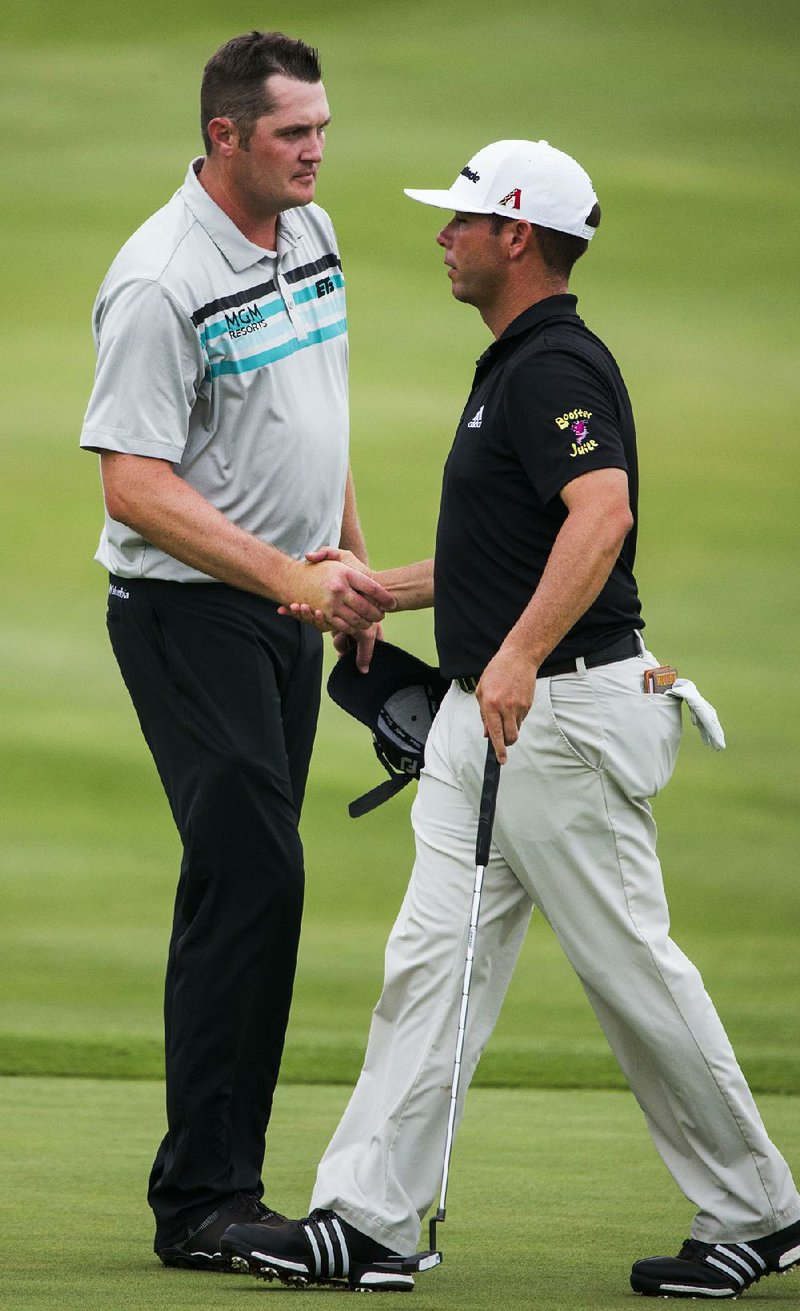 Jason Kokrak, left, shakes hands with Chez Reavie after finishing the second round of the Byron Nelson golf tournament at TPC Four Seasons Resort, Friday, May 19, 2017, in Irving, Texas. 