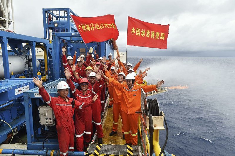 Earlier this week, Chinese workers on a drilling platform in the South China Sea celebrate the successful trial extraction of natural gas from “combustible ice” under the seafloor. Flags read “China Land Resource Bureau” and “Guangzhou Ocean Resource Bureau.” 