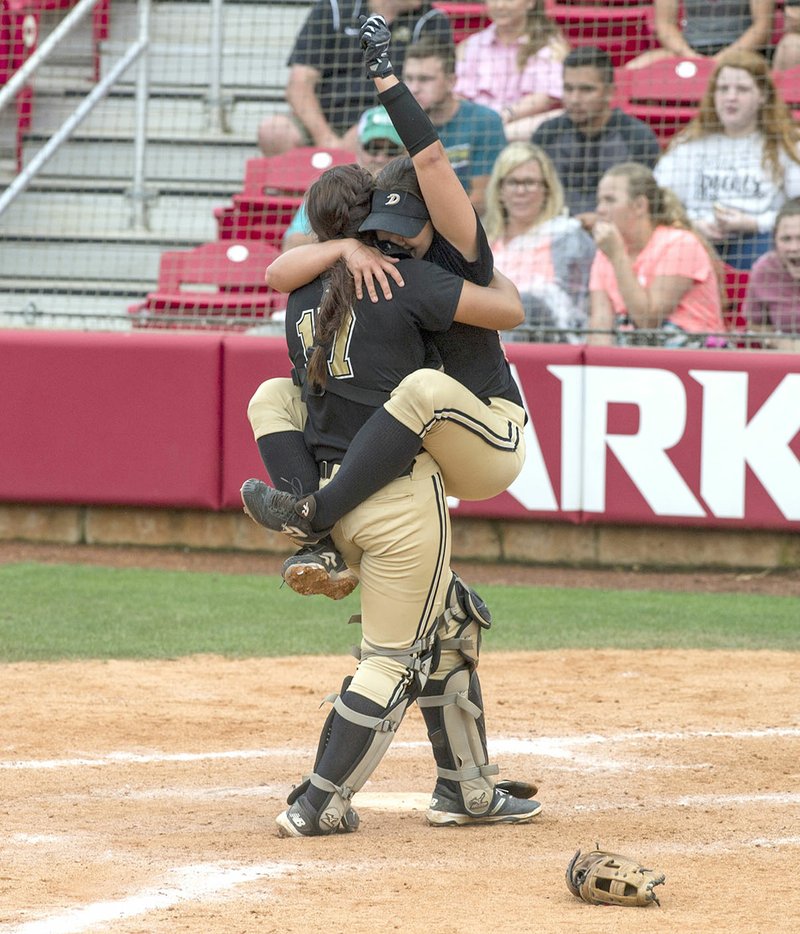 De Queen's Josie Vaught (right) clings to Jessicca Williams on Friday after the final out against Valley View in the Class 5A state softball championship at Bogle Park in Fayetteville.