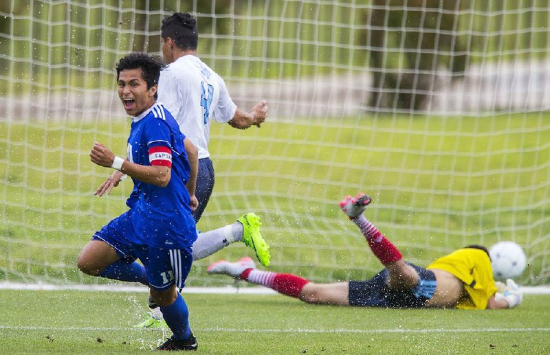 Rogers senior Jessie Ramirez (left) celebrates after scoring one of his three goals Saturday as the Mounties defeated Springdale Har-Ber 5-3 for the Class 7A boys  soccer state championship at Razorback Field in Fayetteville.