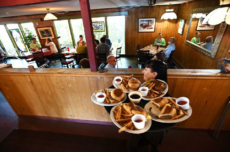 Rayna Warrix hustles a tray of food to a table Wednesday at the Restaurant on the Corner in Fayetteville. The restaurant will close at the end of the month. 