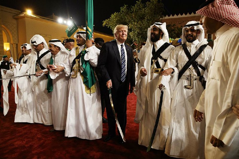 President Donald Trump joins in a traditional Saudi sword dance as part of his grand welcome Saturday at Murabba Palace in Riyadh before the start of a royal dinner. 