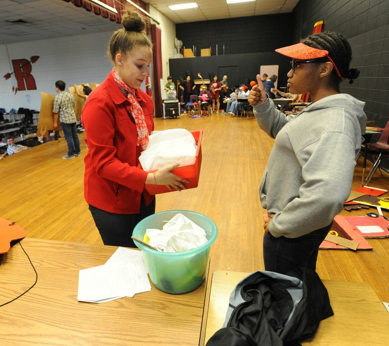 NWA Democrat-Gazette/ANDY SHUPE Dejha Showers (left), 14, an eighth-grader at Ramay Junior High, helps Taliah Bullock, 13, a seventh-grader, with her costume May 10 during a rehearsal for a play the club produced at the school in Fayetteville.