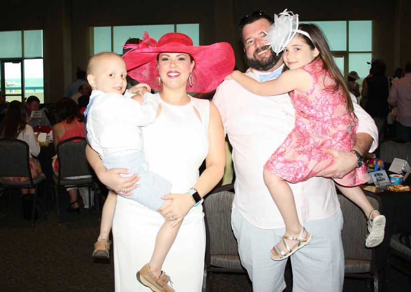 NWA Democrat-Gazette/CARIN SCHOPPMEYER Emily and Brian Avra hold their children Beckett and Austyn at A Nite at the Races on May 6 at Fayetteville Town Center.