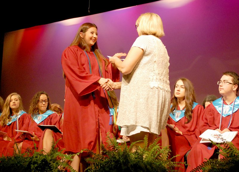 Janelle Jessen/Siloam Sunday School counselor Lesa Eaves presented Dianna Spears with a scholarship during the 41st annual Scholarship Awards Program on Thursday evening. More than $555,000 in local scholarships and $5.7 million in college, military and state financial aid was awarded during the program.