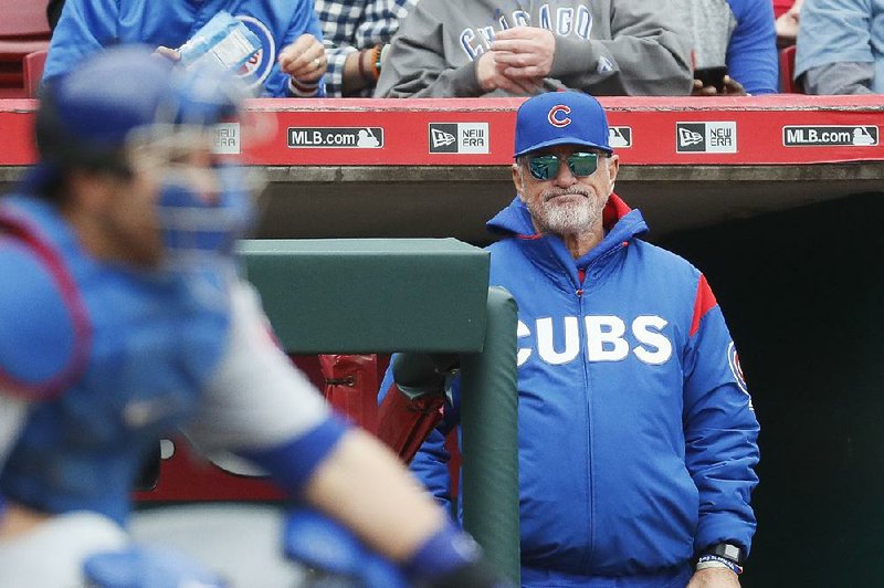 Chicago Cubs manager Joe Maddon (right) stands in the dugout in the sixth inning of a baseball game against the Cincinnati Reds, Sunday, April 23, 2017, in Cincinnati.