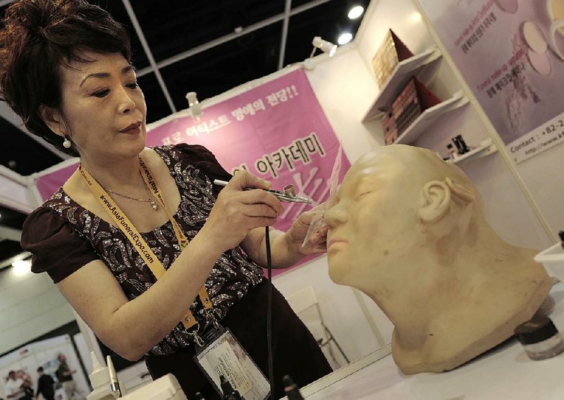 Lee Jong-lan, South Korea’s top funerary beautician, demonstrates her airbrushing technique for covering up discolored or damaged skin on corpses at the Asia Funeral and Cemetery Expo & Conference last week in Hong Kong.