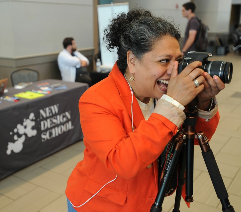 Sonia Gutierrez, founder and chief operating officer of New Design School in Fayetteville, photographs Brian Dodwell of Fayetteville on Thursday during Tech Fest in the Fayetteville Town Center. New Design School operates out of a shared space with Startup Junkie on the square, but school officials hope to move to a permanent location on the first floor of the historic Walker-Stone House.