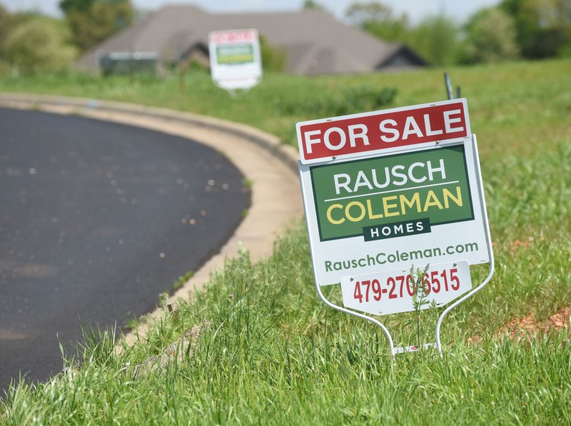 Signs line curbed asphalt streets April 18 at Providence Village subdivision in southwest Bentonville. Many subdivisions that stalled during the recession are beginning to draw developers’ interest.