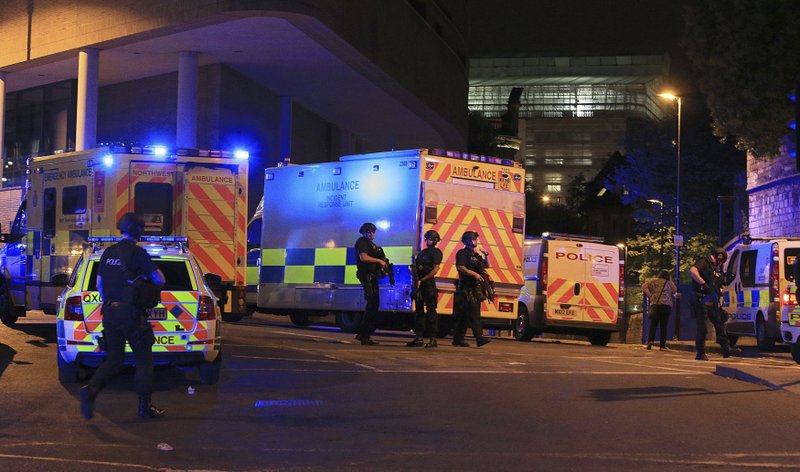 Armed police work at Manchester Arena after reports of an explosion at the venue during an Ariana Grande gig in Manchester, England Monday, May 22, 2017. Several people have died following reports of an explosion Monday night at an Ariana Grande concert in northern England, police said. A representative said the singer was not injured. (Peter Byrne/PA via AP)
