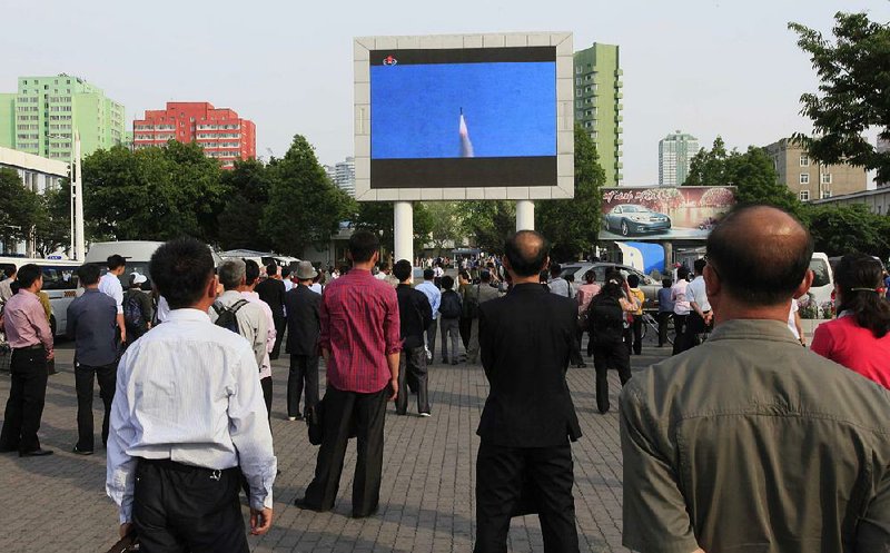 North Koreans watch Monday as a news broadcast on the test-launch of a Pukguksong-2 missile is shown on a screen in front of the railway station in Pyongyang.