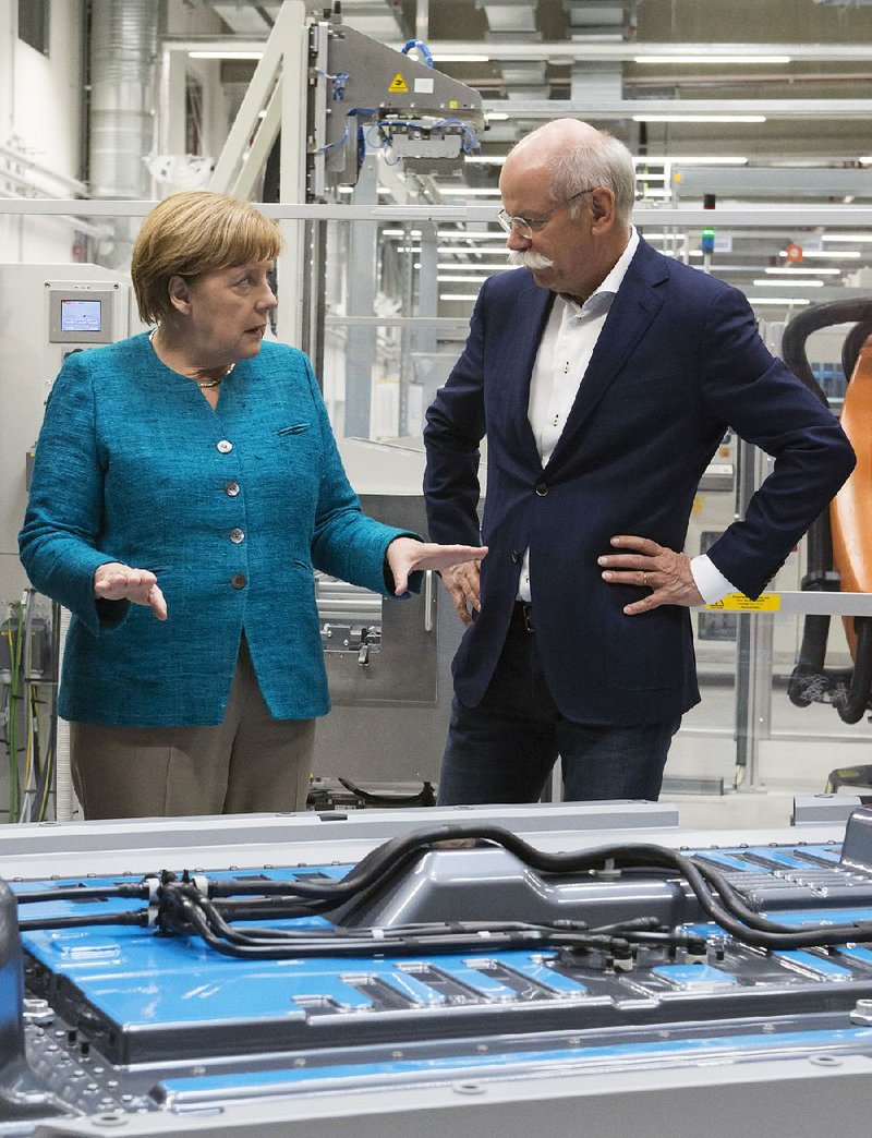 German Chancellor Angela Merkel speaks Monday with Daimler AG Chief Executive Officer Dieter Zetsche during a visit to a production facility in Kamenz, Germany. Merkel later participated in the groundbreaking ceremony for a factory that will make batteries for electric vehicles.