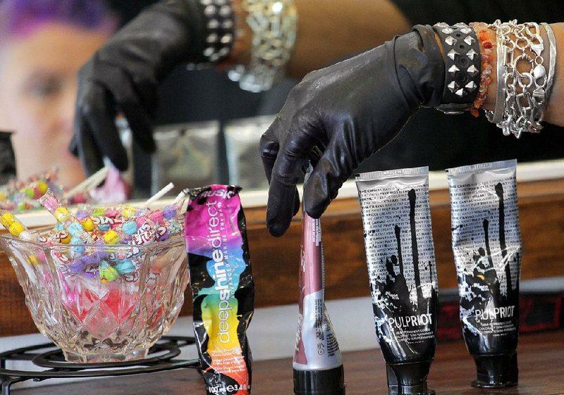 Hairdresser Stacie Mack reaches for tubes of hair color to use on client Andi Stracner at H2O Hair + Color in Little Rock. Stracner is among a growing number of women who opt for hair colors that are far from any human hair colors found in nature.