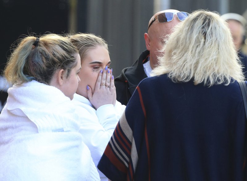 Fan leaves the Park Inn hotel in central Manchester, England, Tuesday, May 23, 2017. Over a dozen people were killed in an explosion following a Ariana Grande concert at the Manchester Arena late Monday evening. (AP Photo/Rui Vieira)
