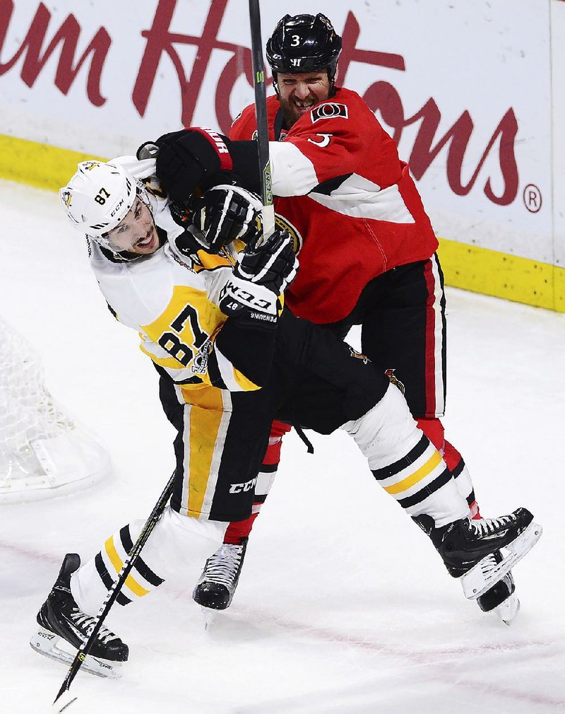 Pittsburgh center Sidney Crosby (left) battles for position with Ottawa defenseman Marc Methot in the second period of Tuesday’s game. 