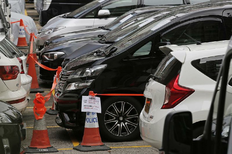 Impounded vehicles belonging to Uber drivers sit parked Tuesday outside a police station in Hong Kong.