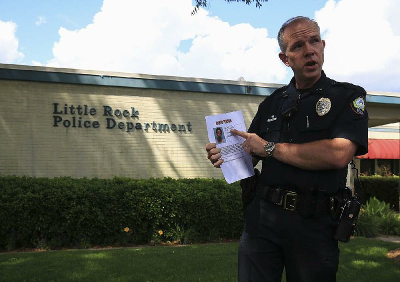 Little Rock police Lt. Steve McClanahan, in announcing the arrest Tuesday of Larry Jackson in the killing of 2-year-old Ramiya Reed, holds a flier on Deshaun Rushing, whom police are still seeking in the case.