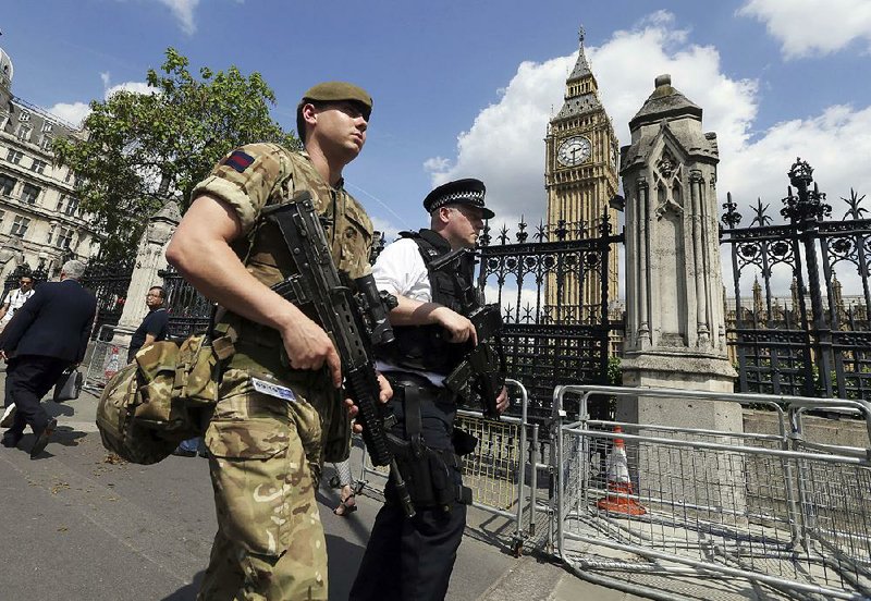 A British soldier joins a police officer on patrol Wednesday in the Westminster area of London as part of increased security after the suicide bomb attack Monday in Manchester that left 22 people dead and scores wounded. Investigators, saying attacker Salman Abedi had not acted alone, were looking for a wider network of plotters. Abedi’s father was arrested Wednesday in Libya, a day after Abedi’s brother was taken into custody, and officials said five people were being held in Britain regarding the attack.  