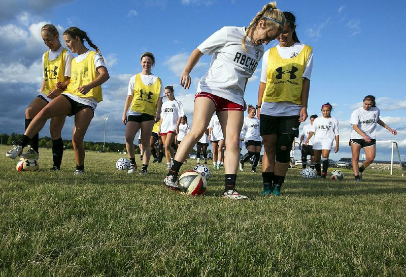 Members of the Little Rock Rangers women’s soccer team loosen up during a practice session Wednesday in preparation for their inaugural season opener against the Memphis Lobos tonight at War Memorial Stadium in Little Rock.