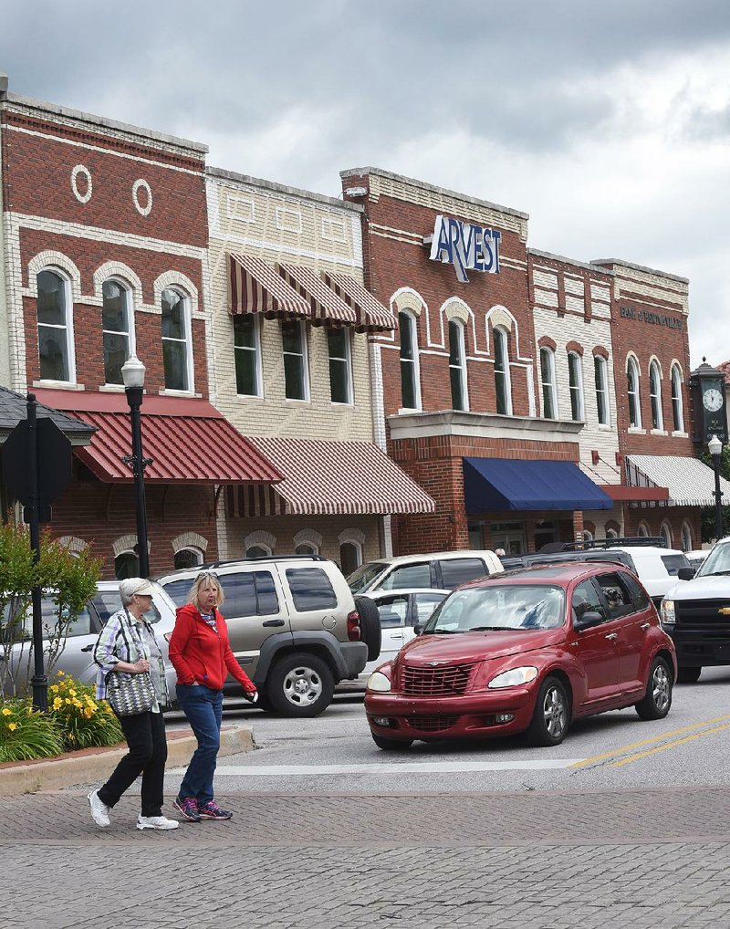 Pedestrians stroll on the Bentonville downtown square Wednesday.The city had the highest rate of growth and the most new residents of the four largest Northwest Arkansas towns, according to the U.S. census data released Wednesday. 