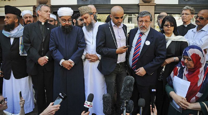 Religious leaders address the crowd Wednesday at a vigil at St. Ann’s Square in Manchester, England. The mosque attended by the suicide bomber denounced Monday’s attack in Manchester, and an official with the Manchester Islamic Center said, “This act of cowardice has no place in our religion, or any other religion.”