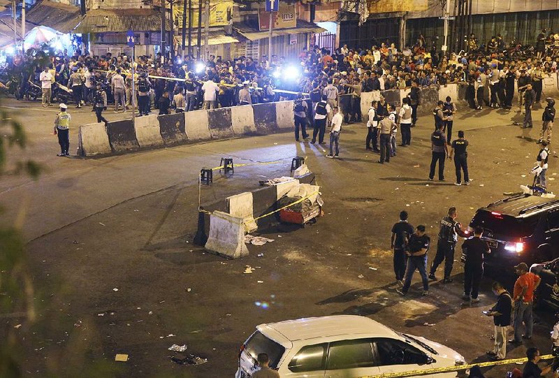 Police officers in Jakarta, Indonesia, clear the area Wednesday where uspected suicide bombings occurred near a bus terminal.