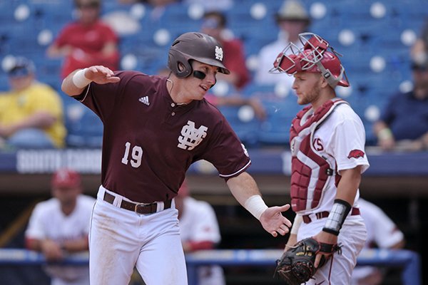 Mississippi State first baseman Brent Rooker celebrates as Arkansas catcher Grant Koch looks on after Rooker scored to take the lead 4-3 in the top of the ninth inning Thursday, May 25, 2017, during the SEC Tournament at Hoover Metropolitan Stadium in Hoover, Ala.
