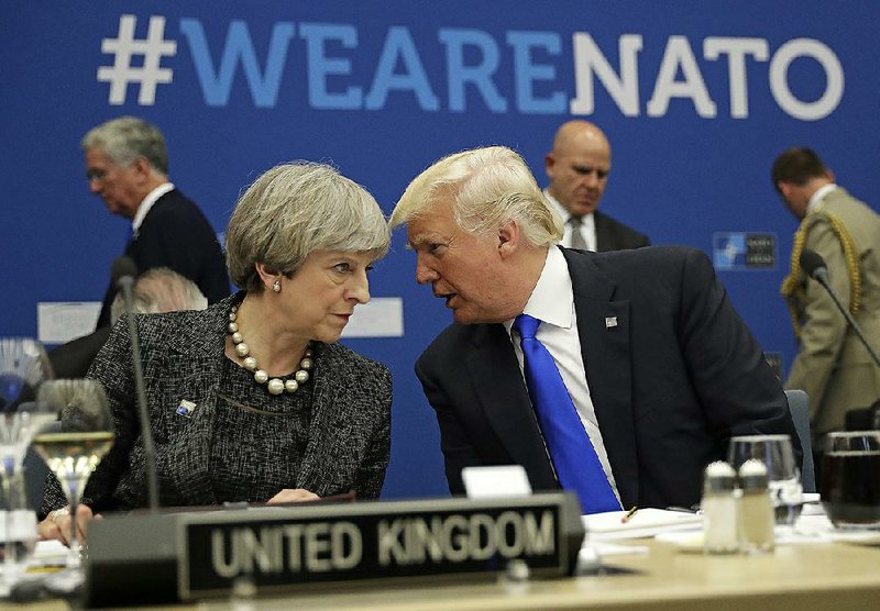 President Donald Trump talks to British Prime Minister Theresa May during a working dinner Thursday at NATO’s new headquarters in Brussels. In remarks primarily about NATO members’ financial commitments, Trump said the U.S. would “never forsake the friends that stood by our side” but appeared to offer no clear commitment of going to member nations’ defense. 
