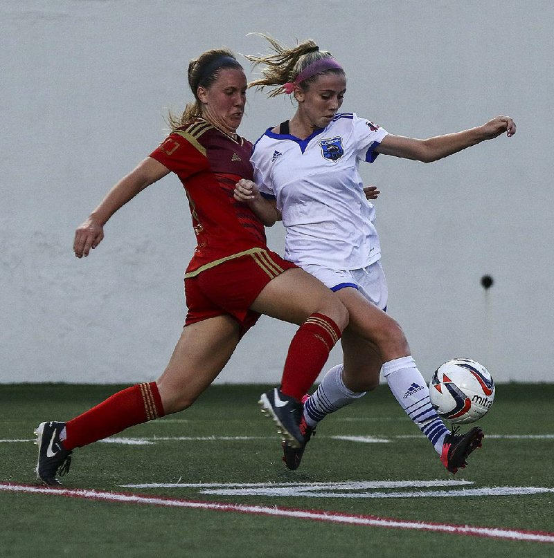 Abigail Persson of the Little Rock Rangers (left) battles with Alex Harber of the Memphis Lobos for the ball during the Rangers’ inaugural game Thursday at War Memorial Stadium in Little Rock. Memphis pulled away to win the match 4-0.
