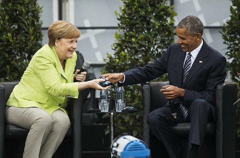 Former U.S. President Barack Obama and German Chancellor Angela Merkel talk about democracy and global responsibility at a Protestant conference Thursday in Berlin. 