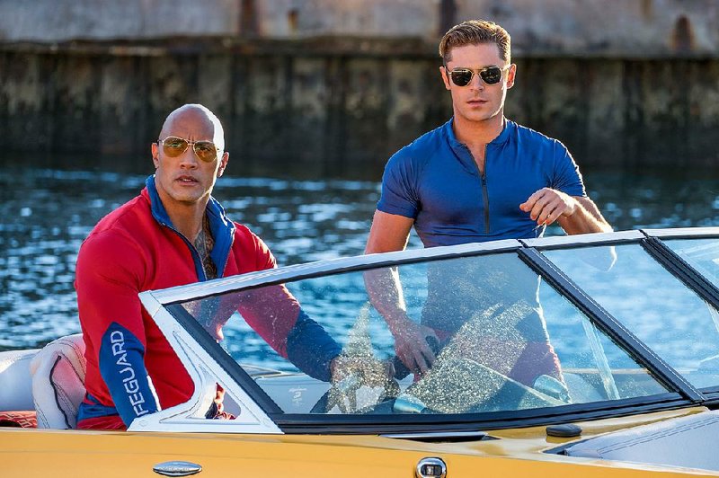 Mitch Buchannon (Dwayne Johnson) and Matt Brody (Zac Efron) patrol the beach and ÿght crime and stuff in Seth Gordon’s Baywatch.
