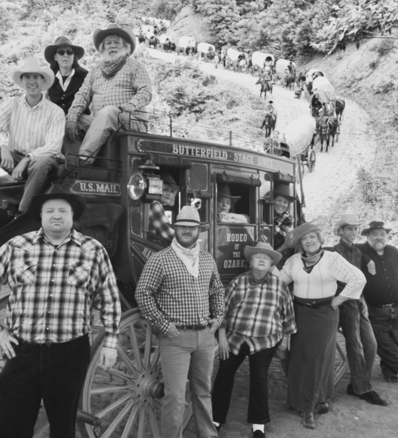 Actors in Northwest Arkansas Audio Theater’s “Westward the Women” pose in front of a stagecoach wagon on loan to them from the Rodeo of the Ozarks.
