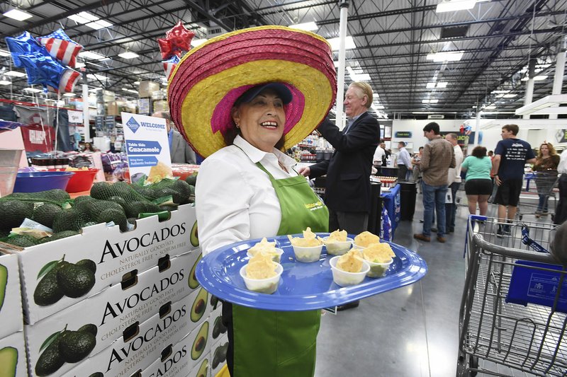 Ginger Edwards of Tulsa, Okla., gives out samples of guacamole Thursday at the opening of the Springdale Sam’s Club. The club is in west Springdale at 56th Street and Sunset Avenue.