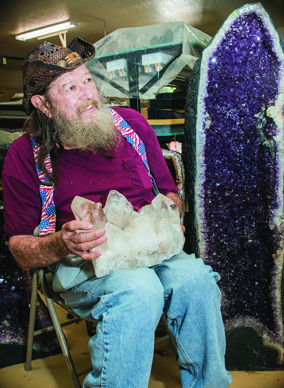 Jim Coleman poses with a host of geodes he has mined over the years. Coleman has mined quartz and other crystals from the mountains of Garland County for 55 years. His mines are the leading producers of Arkansas quartz in the United States, and the roadside location on Arkansas 7 in Jessieville makes his attraction popular among tourists, who can shop, and even mine, for crystals.