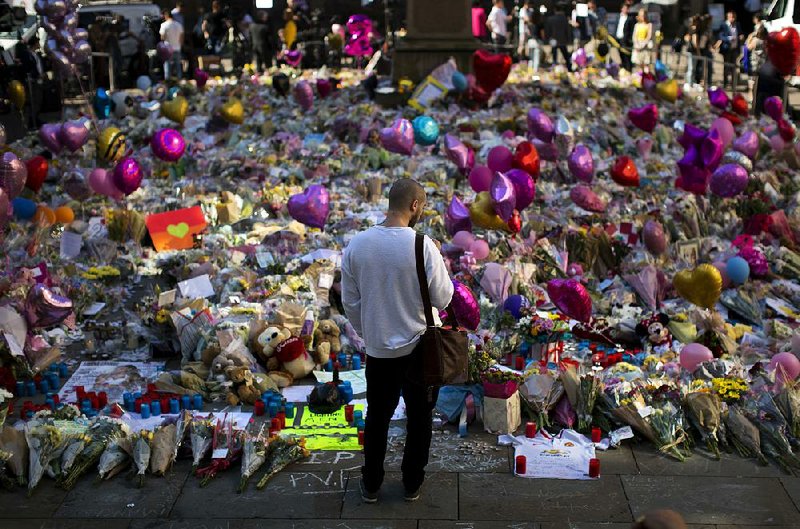 Floral tributes for the victims of the bombing Monday in Manchester, England, cover the ground Friday at the city’s St. Ann’s Square. 