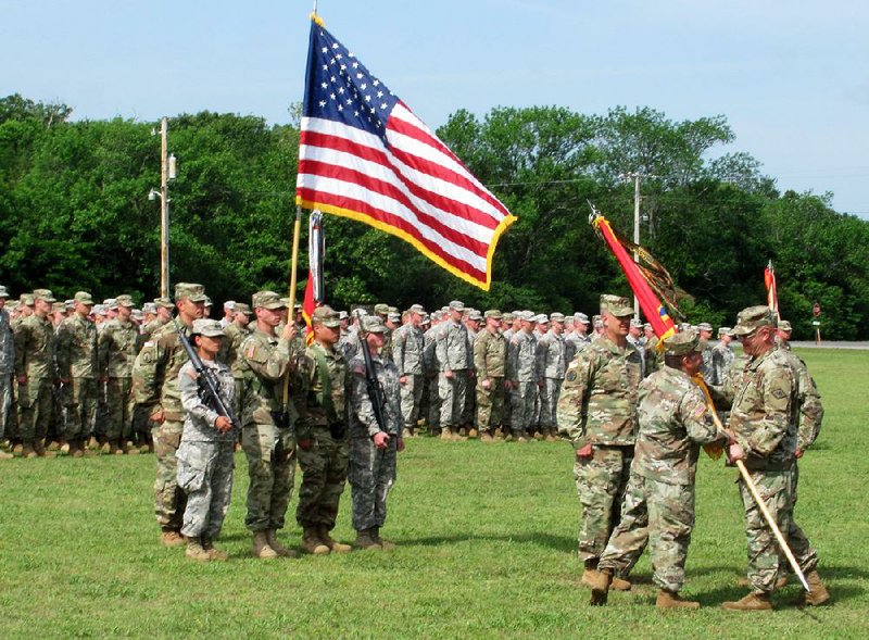Lt. Col. Nicholas Jaskolski (left, foreground) takes command of the Arkansas Army National Guard’s 142nd Field Artillery Brigade on Friday as he accepts the brigade !ag from Brig. Gen. Kirk Van Pelt, Arkansas assistant adjutant general for operations, in a ceremony at Fort Chaffee. 