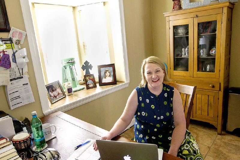 Photo of Christie Ison at her desk in her kitchen.