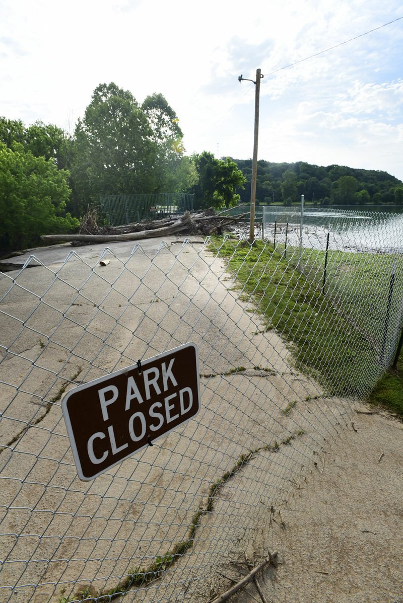 The Lake Bella Vista’s trail has been closed since heavy ran ooded the lake and piled wood and debris on the dam earlier this month.