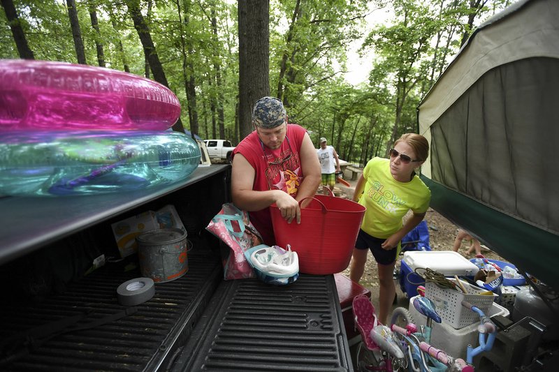 Ryan and Courtney Bensch of Wichita Kan., prepare to leave their campsite Friday for some time on Beaver Lake at the Prairie Creek Recreation Area and Campground near Rogers. Out of the roughly 680 camping sites along Beaver Lake, 117 are closed due to high water and flooding, but three or four sites are still available.
