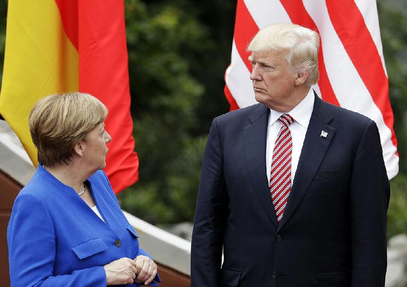 German Chancellor Angela Merkel talks with President Donald Trump during a group photo session for Group of Seven leaders Friday in the Sicilian citadel of Taormina. Merkel said the leaders had a “very intense exchange” on the need for U.S. commitment to the 2015 climate accord. 
