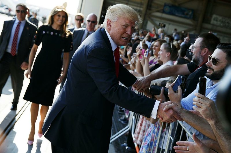 President Donald Trump shakes hands Saturday as he arrives to speak to U.S. troops and their families at Naval Air Station Sigonella in Italy. 