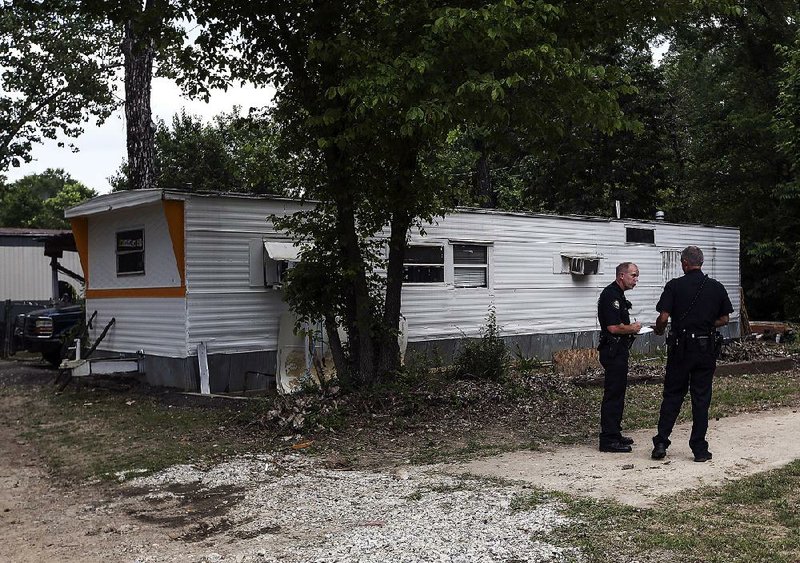 Little Rock police spokesman Lt. Steve McClanahan (left) discusses the details of a homicide investigation with police spokesman Steve Moore on Saturday in southwest Little Rock.