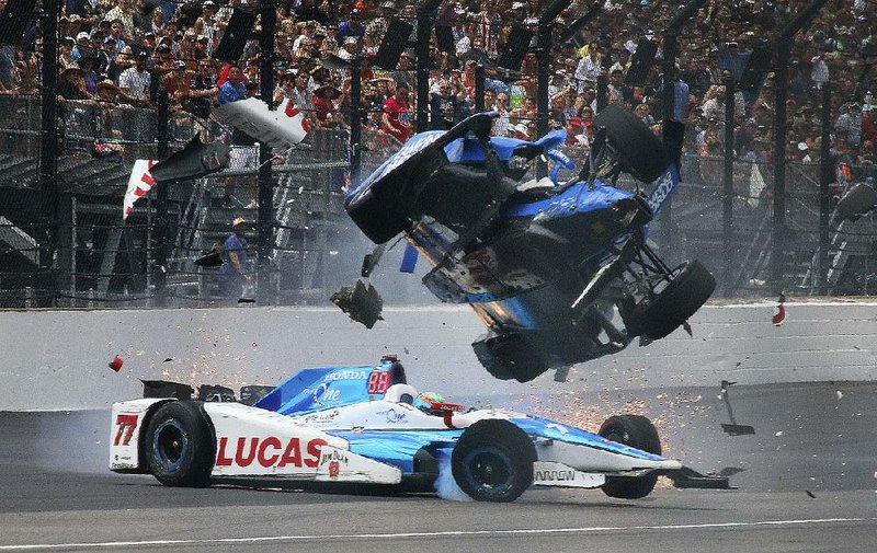 Indianapolis 500 pole-sitter Scott Dixon (right) goes airborne in his car after crashing into Jay Howard after coming out of the first turn during Sunday’s race. Dixon and Howard were both examined by medical personnel and came away from the accident uninjured.