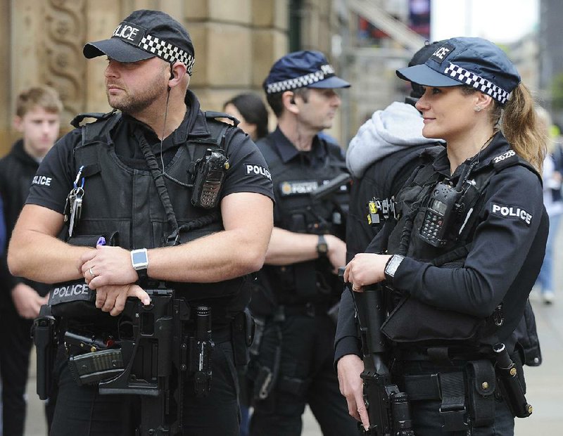 Police in Manchester, England, stand guard Sunday at the start of the Great Manchester Run. 