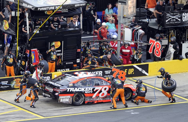 Crew members perform a pit stop on driver Martin Truex Jr's car during the NASCAR Cup series auto race at Charlotte Motor Speedway in Concord, N.C., Sunday, May 28, 2017. (AP Photo/Mike McCarn)