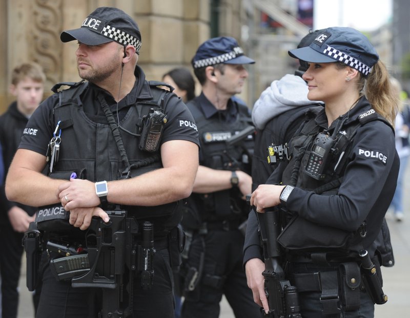 Armed response police stand at the start of the Great Manchester Run in central Manchester, England Sunday May 28 2017. More than 20 people were killed in an explosion following a Ariana Grande concert at the Manchester Arena late Monday evening.