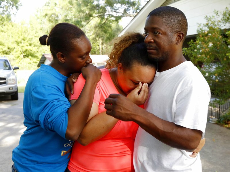 Christianna May-Kelly, center, is supported by family members as she cries after answering reporters questions outside her parents' home in Brookhaven, Miss., Sunday, May 28, 2017. May-Kelly said her parents and mother were among the people gunned down during a shooting in rural Mississippi Saturday night. 