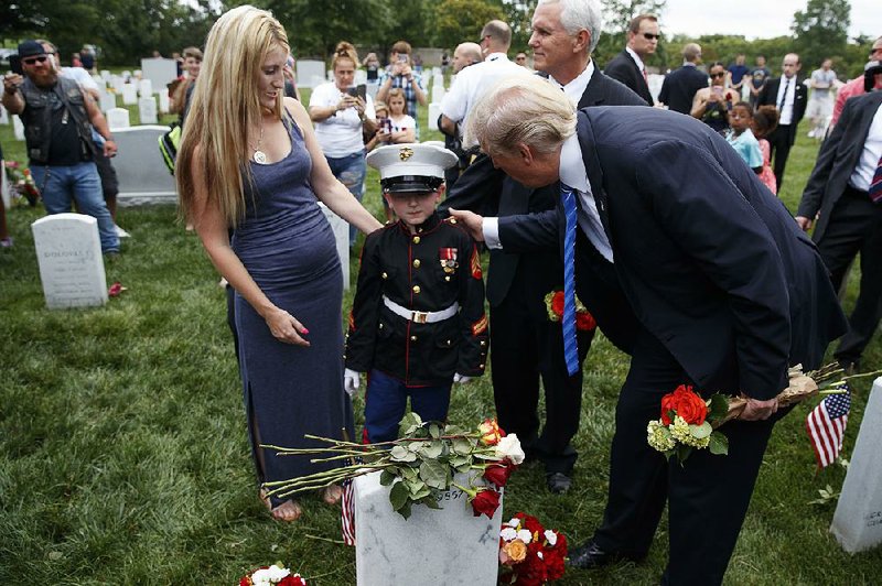 Brittany Jacobs (left) watches as her son, Christian Jacobs, 6, meets President Donald Trump (right) and Vice President Mike Pence on Monday at Arlington National Cemetery in Virginia. Christian’s father, Marine Sgt. Christopher Jacobs, died in a training accident in 2011.